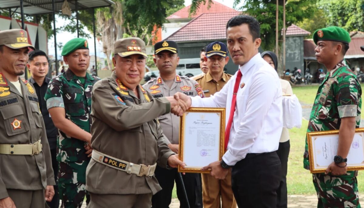 Bupati Tanggamus H. Moh. Saleh Asnawi saat menyerahkan piagam penghargaan kepada perwakilan Polres Tanggamus di Lapangan Merdeka, Kota Agung, Selasa 13 Januari 2026 | Herdi/Media Prioritastv.com.
