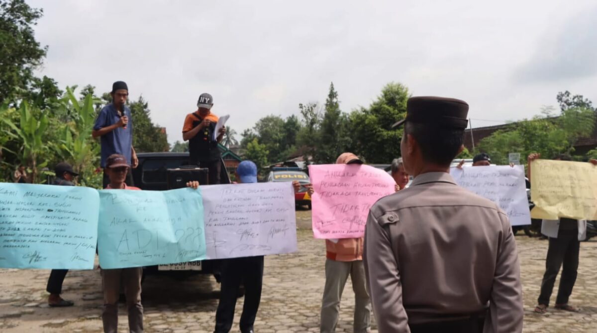 Warga Pekon Banjarnegeri Kecamatan Gunung Alip Kabupaten Tanggamus membentangkan poster saat menggelar aksi di Pekon setempat, Senin 19 Januaro 2026 | Herdi/Media Prioritastv.com.