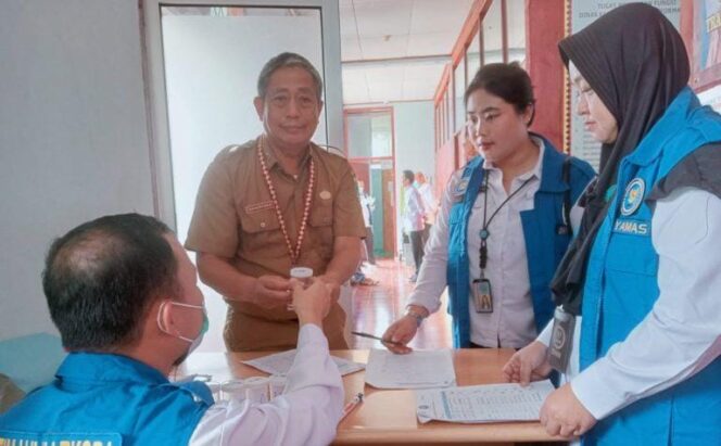 Kadis Kominfo Tanggamus Suhartono saat memperlihatkan hasil test urine dalam rangkaian pemeriksaan oleh BNNK, Senin 19 Januari 2026 | Dok. Kominfo Tanggamus.