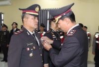 Wakapolres Pringsewu Kompol Samsuri saat menyematkan tanda Satyalencana Pengabdian 32 tahun kepada Kapolsek Pagelaran Iptu Agus Dharmawan, Kamis 22 Januari 2026 | Dok. Humas Polres Pringsewu.