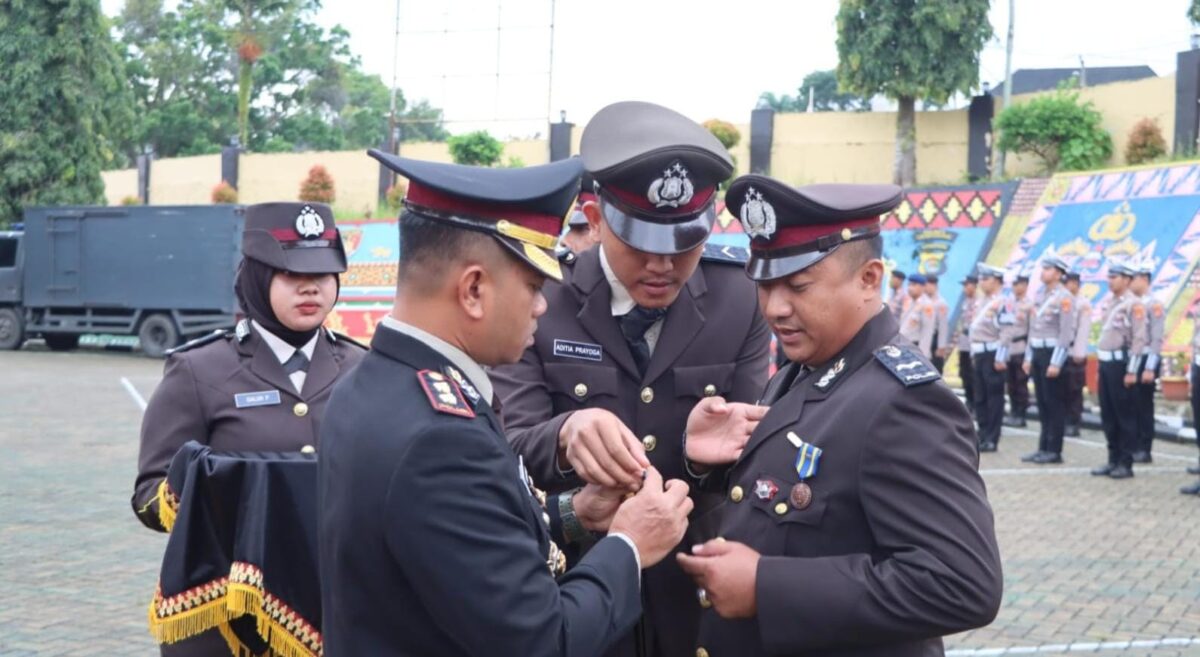Kapolres Tanggamus AKBP Rahmad Sujatmiko saat menyematkan penghagaan Satyalencana Pengabdian 16 tahun kepada Aipda Epri Mohansyah di Lapangan Mapolres Tanggamus, Jumat 23 Januari 2026 | Dok. Humas Polres Tanggamus.