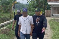 Tersangka MT saat digelandang polisi menuju Polres Pringsewu, Jumat 23 Januari 2026, siang | Dok. Humas Polres Pringsewu.