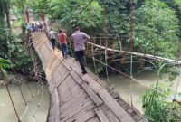 Polisi saat melintasi jembatan gantung Jati Agung, Pekon Banjar Agung Ilir, Kecamatan Pugung, Kabupaten Tanggamus yang rusak usai dilintasi angkutan umum, Senin 9 Februari 2026 | Herdi/Media Prioritastv.com.