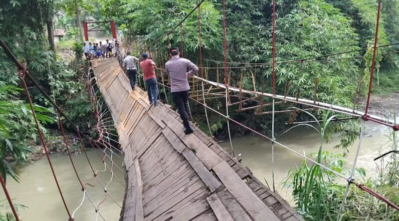 Polisi saat melintasi jembatan gantung Jati Agung, Pekon Banjar Agung Ilir, Kecamatan Pugung, Kabupaten Tanggamus yang rusak usai dilintasi angkutan umum, Senin 9 Februari 2026 | Herdi/Media Prioritastv.com.