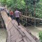 Polisi saat melintasi jembatan gantung Jati Agung, Pekon Banjar Agung Ilir, Kecamatan Pugung, Kabupaten Tanggamus yang rusak usai dilintasi angkutan umum, Senin 9 Februari 2026 | Herdi/Media Prioritastv.com.