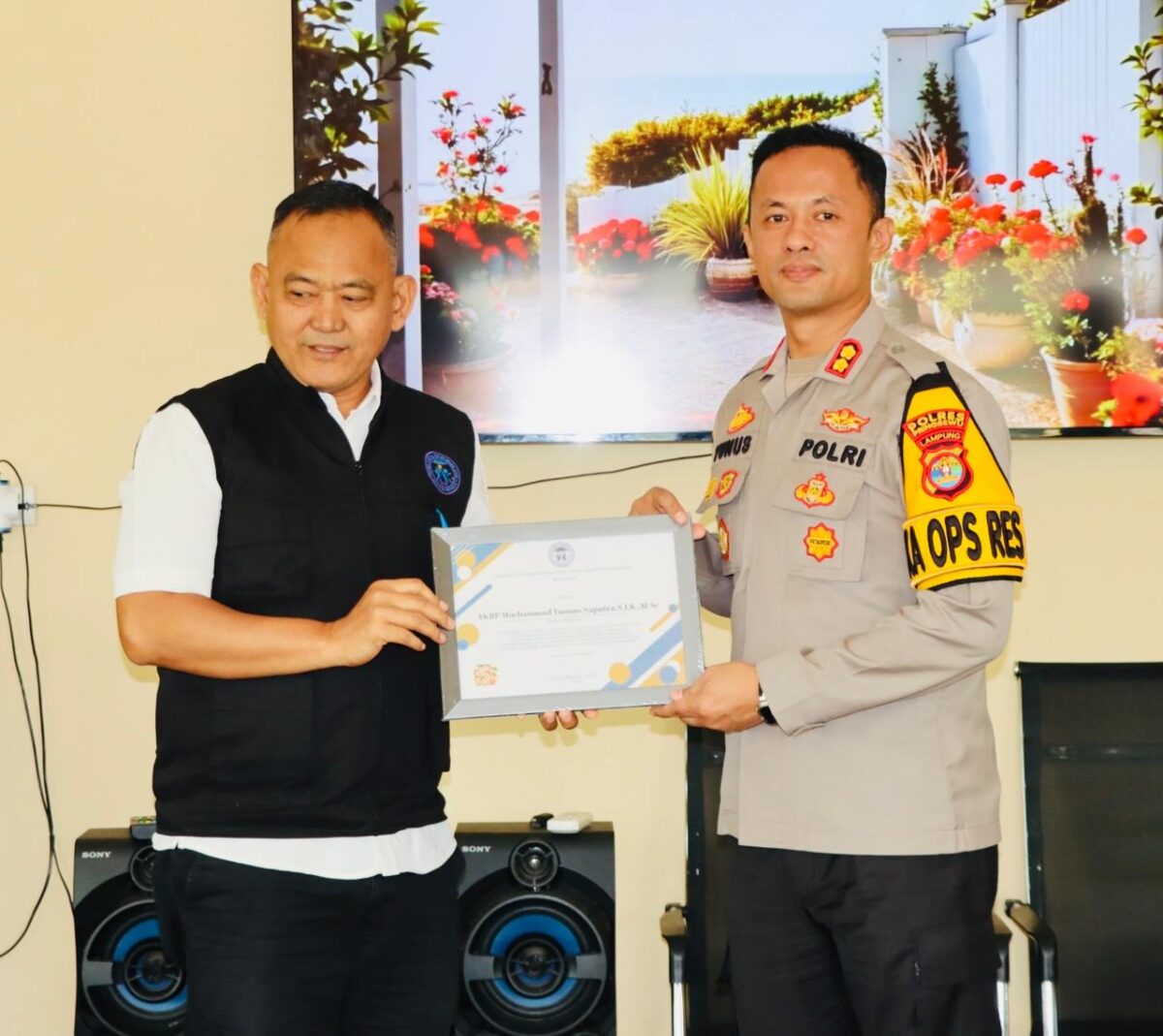 Dr. H Fauzi menyerahkan penghargaan kepada Kapolres Pringsewu sebagai bentuk apresiasi atas komitmen dan keberhasilan penanganan 68 kasus kekerasan anak dan perempuan sepanjang 2025.(foto: Prioritas tv.com/Istimewa)