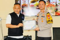 Dr. H Fauzi menyerahkan penghargaan kepada Kapolres Pringsewu sebagai bentuk apresiasi atas komitmen dan keberhasilan penanganan 68 kasus kekerasan anak dan perempuan sepanjang 2025.(foto: Prioritas tv.com/Istimewa)