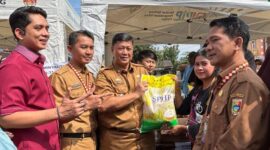 Asisten II Bidang Perekonomian dan Pembangunan Pemkab Tanggamus, Hendra Wijaya Mega saat menyerahkan beras dalam pasar murah di Talang Padang, Selasa 10 Maret 2026 | Herdi/Media Prioritastv.com.
