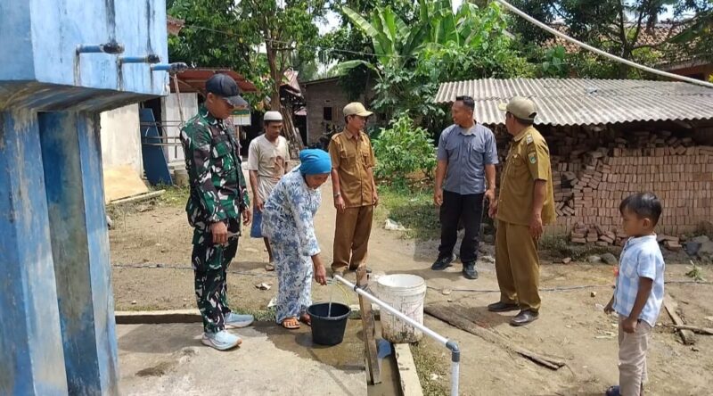 Warga mengambil air bersih dari hasil pengeboran sumur bor yang disaksikan Serda Rosidi, anggota Satgas TMMD ke-128 Kodim 0424/Tanggamus, bersama Kepala Pekon Kalimiring Syaefullah di Pekon Kalimiring, Selasa (2/5/2026) | Herdi/Prioritastv.com.