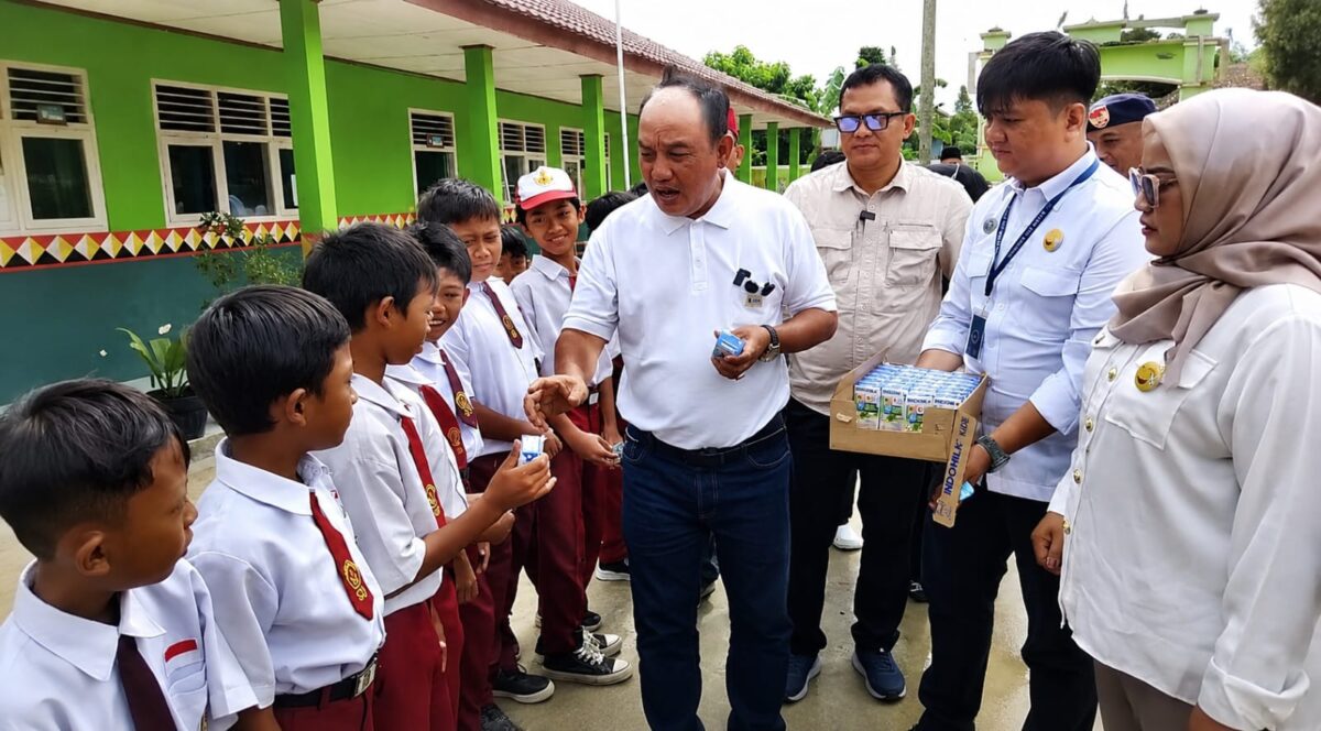 Azis Gagap didampingi Ketua Rel MBG Pusat Roy Marzuk dan ketua Yayasan Alam Abadi Tanggamus Firlinda saat membagikan susu kepada pelajar SD Negeri 3 Gisting Atas Kecamatan Gisting Tanggamus, Senin 25 Mei 2026 | Herdi/Media Prioritastv.com.