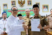 Bupati Pesisir Barat Dedi Irawan dan Kepala Balai Besar TNBBS, Hifzon Zawahiri saat menunjukan berkas PKS di Ruang Rapat Payung Agung, Gedung A Lantai 4 Pemkab Pesisir Barat, Selasa (9/6/2026) | Suroso/Media Prioritastv.com.