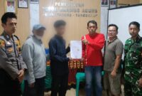 Wahyudi saat menuunjukan surat perdamaian dengan terduga pelaku yang didampingi orang tuanya di Balai Pekon Banding Agung, Talang Padang, Selasa 9 Juni 2026 | Dok. Humas Polres Tanggamus.