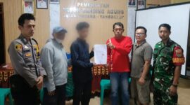 Wahyudi saat menuunjukan surat perdamaian dengan terduga pelaku yang didampingi orang tuanya di Balai Pekon Banding Agung, Talang Padang, Selasa 9 Juni 2026 | Dok. Humas Polres Tanggamus.