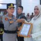 Kapolres Lampung Timur AKBP Heti saat menyerahkan piagam penghargaan kepada Yunia Nur Asiah Ashofah salah satu penolong korban begal, Senin 15 Juni 2026 | Dok. Humas Polres Lampung Timur.