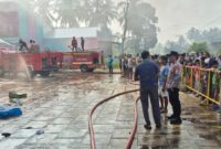 Petugas Damkarmat Tanggamus yang menerjunkan dua mobil pemadam saat berjibaku memadakan api di Toko Swalayan Diamon Pekon Dadimulyo, Wonosobo, Minggu 27 Juni 2026 | ist/Media Prioritastv.com.