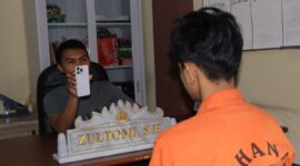 Penyidik saat menunjukan handphone iPhone yang dicuri tersangka yang sebelumnya diberikan kepada kekasih sebagai hadiah, Rabu 29 Juli 2026 | Dok. Humas Polres Tanggamus.