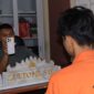 Penyidik saat menunjukan handphone iPhone yang dicuri tersangka yang sebelumnya diberikan kepada kekasih sebagai hadiah, Rabu 29 Juli 2026 | Dok. Humas Polres Tanggamus.