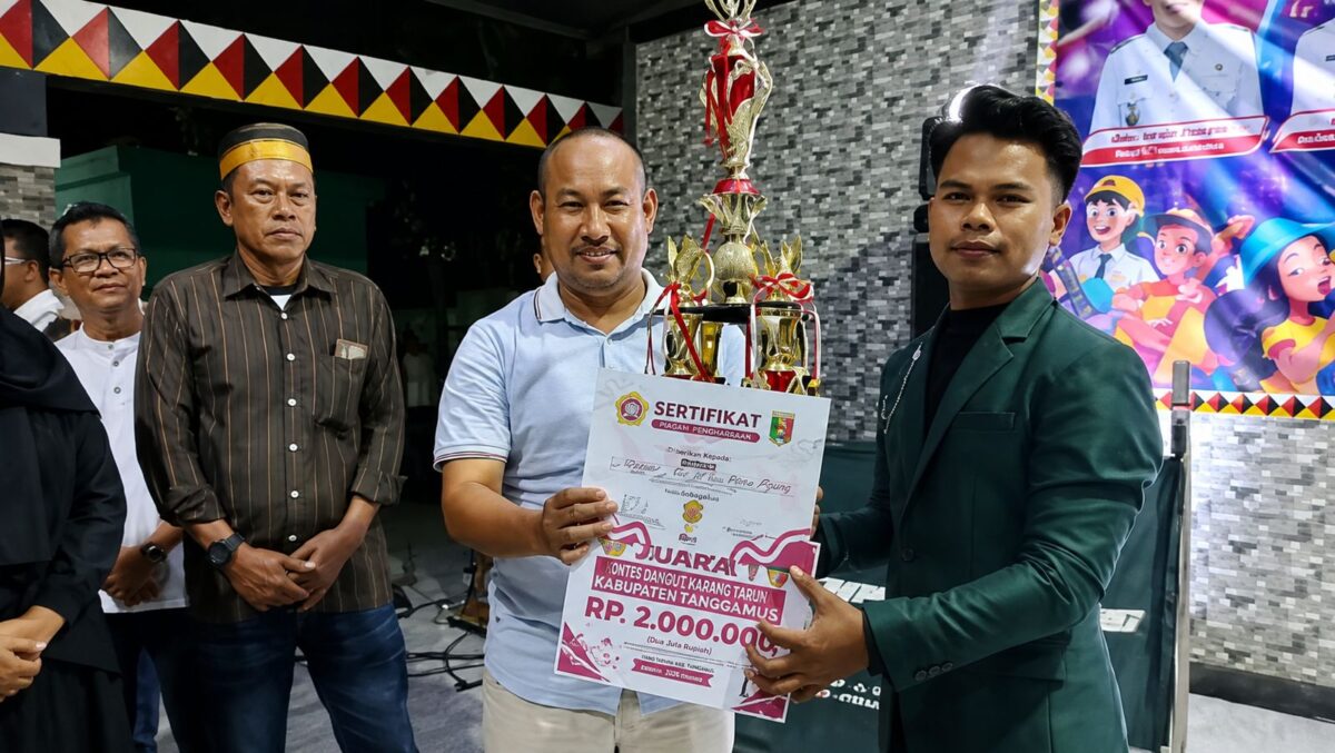 Razes saat menerima piala dan uang tunai atas raihan juara kontes Dangdut Karang Taruna di Taman Soekarno Kota Agung Tanggamus, Sabtu 29 Agustus 2026, malam | Herdi/Media Prioritastv.com.