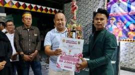 Razes saat menerima piala dan uang tunai atas raihan juara kontes Dangdut Karang Taruna di Taman Soekarno Kota Agung Tanggamus, Sabtu 29 Agustus 2026, malam | Herdi/Media Prioritastv.com.