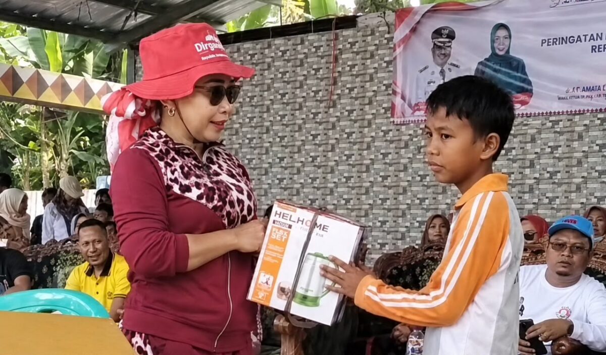Ketua DPK Apdesi Kota Agung Tanggamus Neneng Rohani, S.E., yang juga merupakan Kakon Kota Agung saat menyerahkan salah satu hadiah kepada peraih doorprize di Taman IR Seokarno, Sabtu 22 Agustus 2026 | Zulkarnain/Media Prioritastv.com.