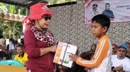 Ketua DPK Apdesi Kota Agung Tanggamus Neneng Rohani, S.E., yang juga merupakan Kakon Kota Agung saat menyerahkan salah satu hadiah kepada peraih doorprize di Taman IR Seokarno, Sabtu 22 Agustus 2026 | Zulkarnain/Media Prioritastv.com.