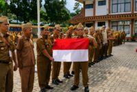 Sekda Tanggamus Suadi saat menyerahkan bendera merah putih kepada Kadis Perhubungan M. Sabar Sitanggang usai apel di Lapangan belakang kantor  Bupati, Senin 10 Agustus 2026 | Herman/Media Prioritastv.com.