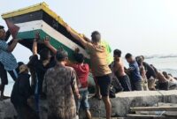 Nelayan saat bergotong royong mengevakuasi perahu yang rusak diterjang gelombang tinggi, Rabu 12 Agustus 2026 | Herdi/Media Prioritastv.com.