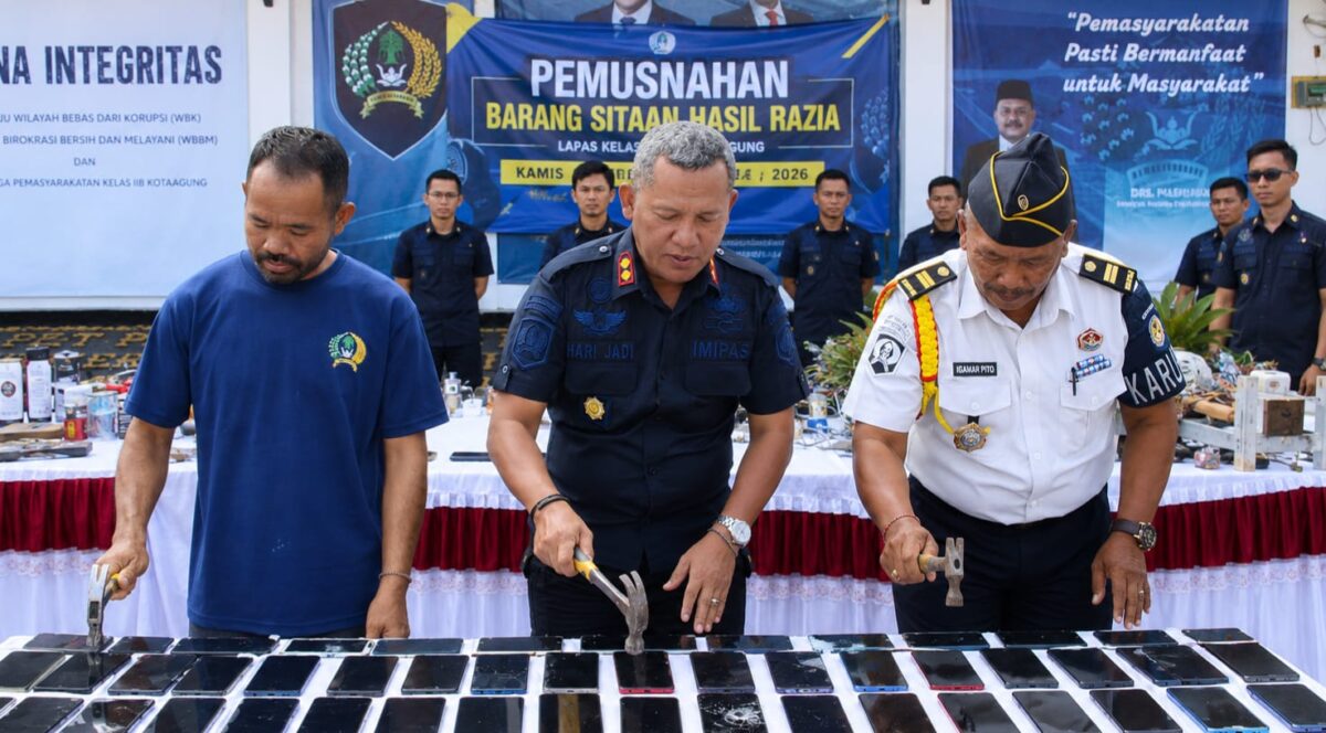 Kalapas Kelas IIb Kota Agung Ruh Harijadi saat memusnkan handphone menggunakan palu dalam pemusnahan barang bukti di Lapas setempat, Kamis 13 Agustus 2026 | Zulkarnain/Media Prioritastv.com.