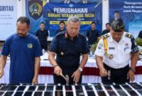 Kalapas Kelas IIb Kota Agung Ruh Harijadi saat memusnkan handphone menggunakan palu dalam pemusnahan barang bukti di Lapas setempat, Kamis 13 Agustus 2026 | Zulkarnain/Media Prioritastv.com.