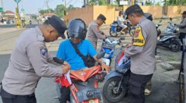 Pembagian dan pemasangan bendera merah putih oleh anggota Polsek Kota Agung di Jalinbar Tanggamus, Minggu 16 Agustus 2026 | Dok. Humas Polres Tanggamus.