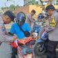Pembagian dan pemasangan bendera merah putih oleh anggota Polsek Kota Agung di Jalinbar Tanggamus, Minggu 16 Agustus 2026 | Dok. Humas Polres Tanggamus.