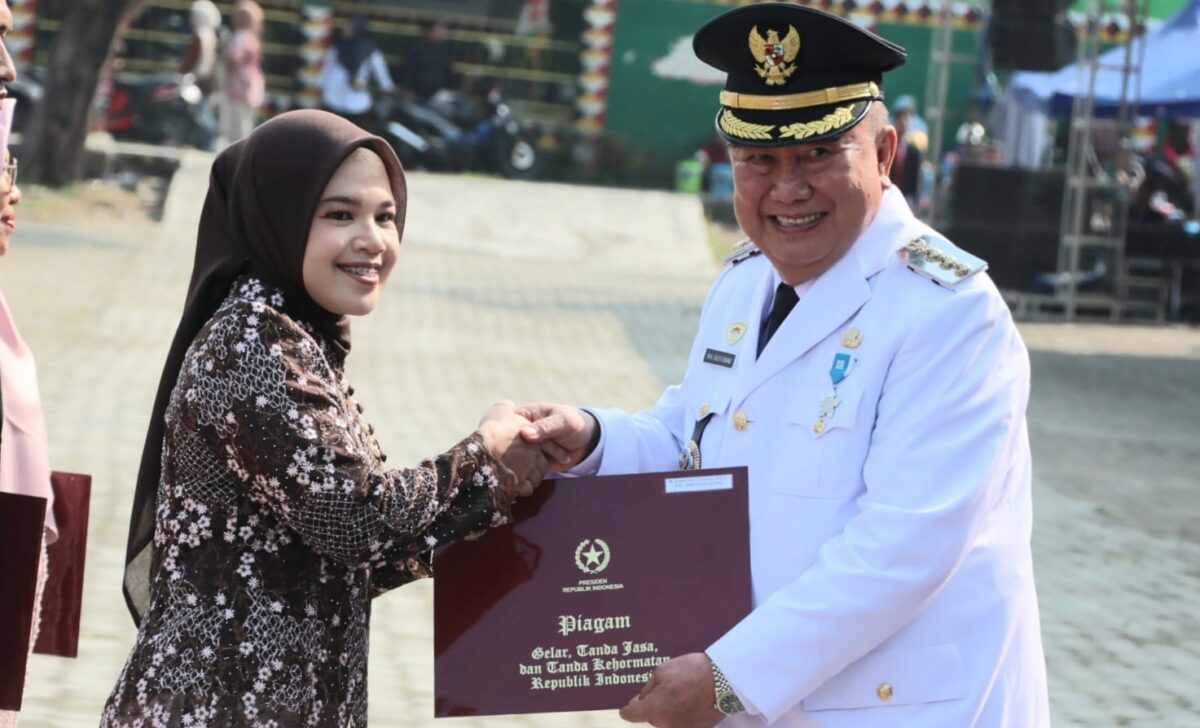 Bupati Tanggamus H. Moh. Saleh Asnawi saat menyerahkan piagam Satya Lencana usai upacara HUT ke 81 Republik Indonesia di Lapangan Merdeka, Kota Agung, Senin 17 Agustus 2026 | Herdi/Media Prioritastv.com.