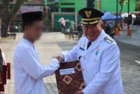 Bupati Tanggamus H. Moh. Saleh Asnawi saat menyerahkan SK Remisi Umum 2026 kepada salah satu perwakilan di Lapangan Merdeka, Kota Agung, Senin 17 Agustus 2026 | Dok. Media Prioritastv.com.