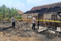 Polisi saat melakukan pemeriksaan TKP dan pemasangan garis polisi di rumah terbakar di Pekon Margodadi, Ambarawa, Pringsewu, Kamis 27 Agustus 2026 | Dok : Humas Polres Pringsewu.
