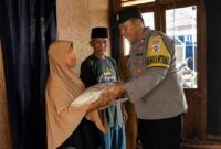 Bhabinkamtibmas Polres Tanggamus Aiptu Rasdin saat menyerahkan bantuan sosial kepada orang tua korban di Pekon Taman Sari Kecamatan Pugung, Senin 24 Agustus 2026 | Dok. Humas Polres Tanggamus.