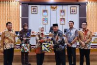 Bupati Tanggamus H. Moh. Saleh Asnawi saat menyerahkan cindramata kepada tim Tim Program Local Service Delivery Improvement Project (LSDP) di Ruang Rapat Utama (Rupatama) Kantor Bupati Tanggamus, Kamis (3/9/2026).