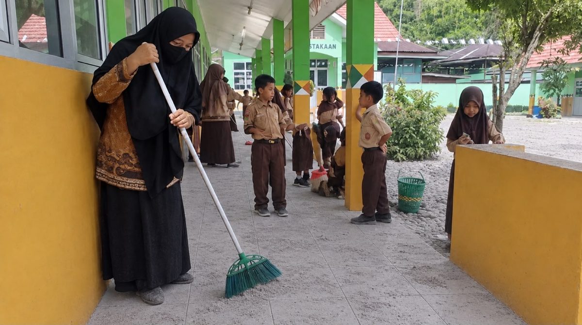 Seorang guru saat membersihkan debu vulkanik di salah satu SD di wilayah Tanggamus, Sabtu 5 Sepetember 2026 | ist/Media  Prioritastv.com.