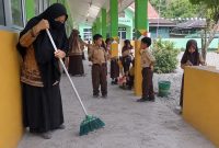 Seorang guru saat membersihkan debu vulkanik di salah satu SD di wilayah Tanggamus, Sabtu 5 Sepetember 2026 | ist/Media  Prioritastv.com.